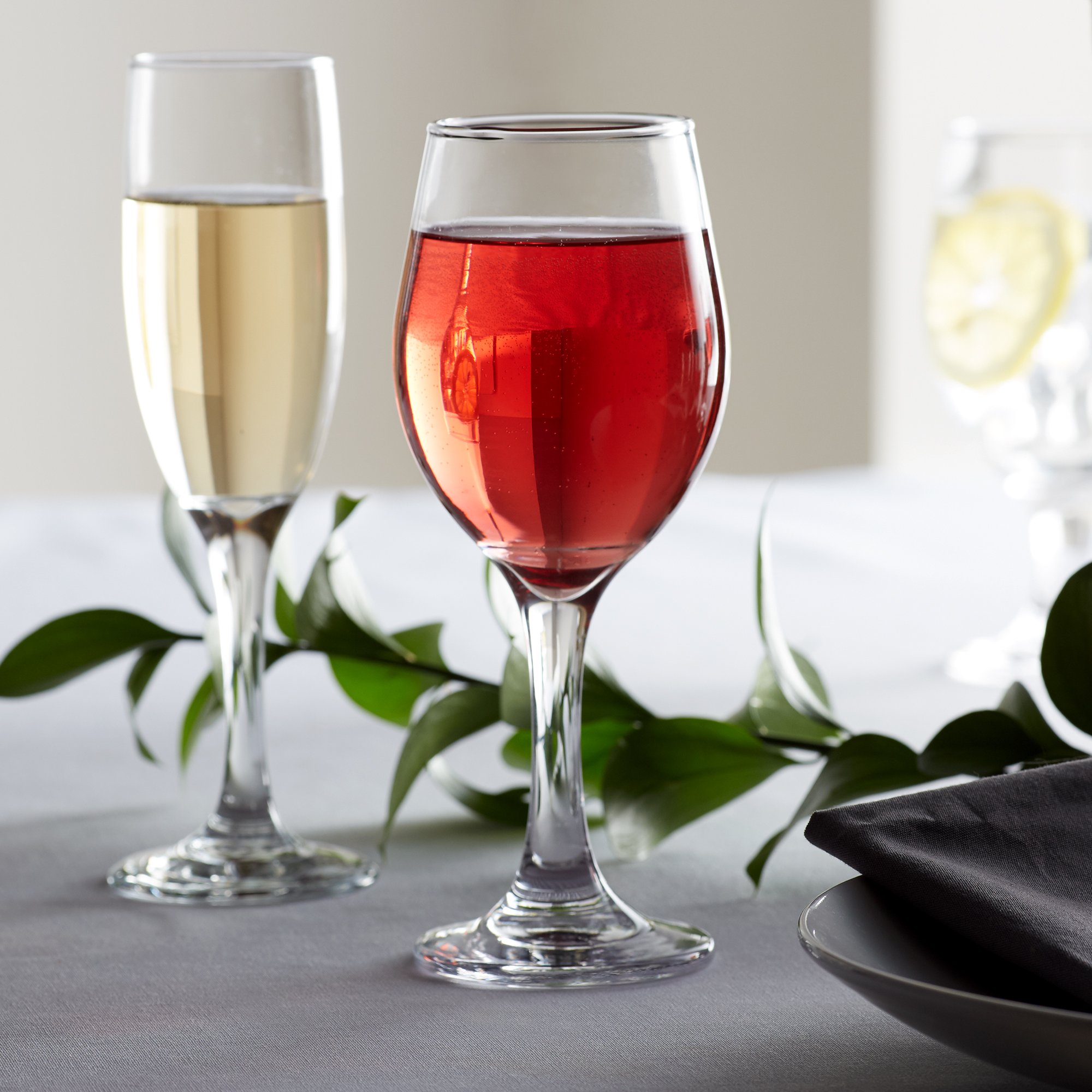 Two stemmed wine glasses filled with wine on an elegant table