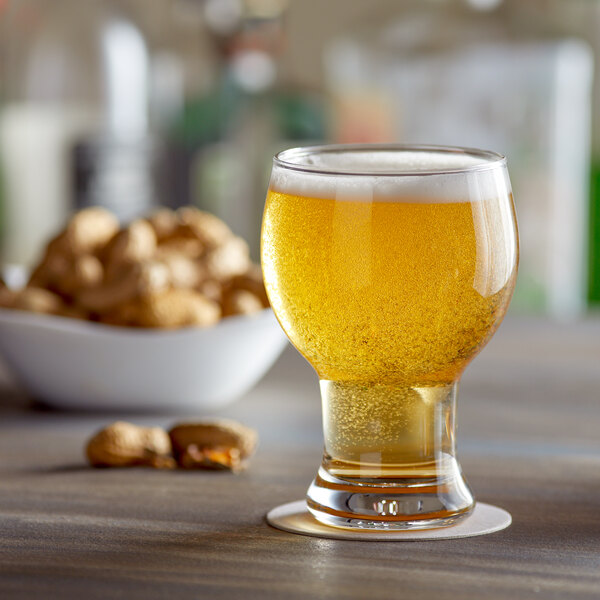 Craft beer glass with a large bowl holds a fizzy light amber brew