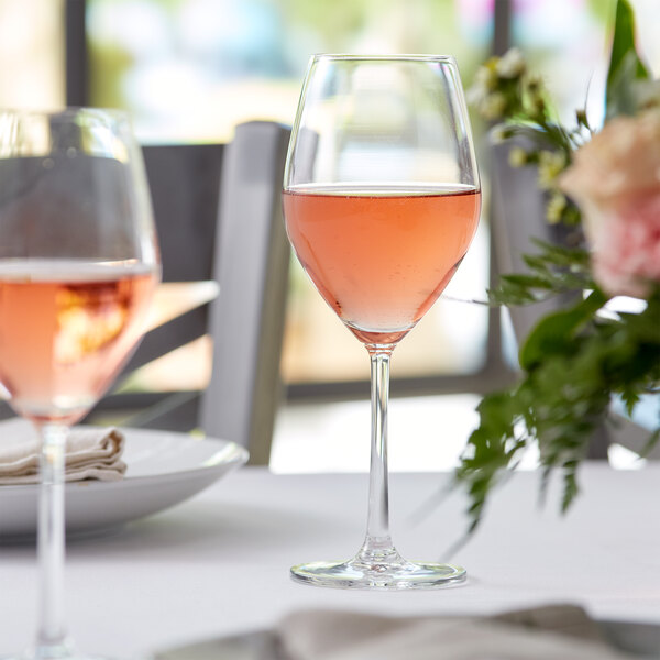 Standard red wine glass filled with rose-colored wine on an elegant table