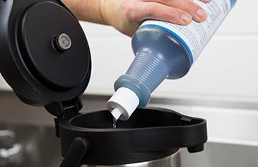 cleaning solution being poured inside of coffee airpot