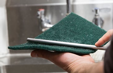 scouring pad with cleaning solution scrubbing the outside of the airpot stem