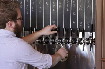 bartender demonstrating how to pour a draft beer