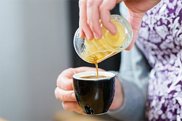 pouring espresso into a mug
