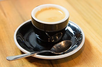 espresso in a black espresso mug on a saucer