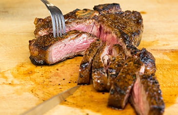medium rare steak on a wooden cutting board