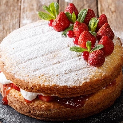 victoria sponge sandwich cake with strawberries and whipped cream