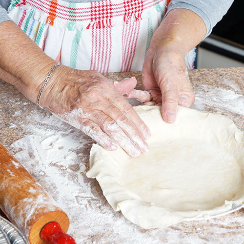 woman's hands shaping pie crust dough