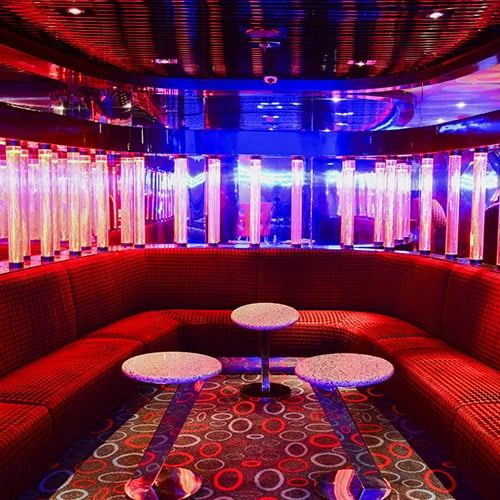 Night club seating with red velvet upholstery and mood lighting
