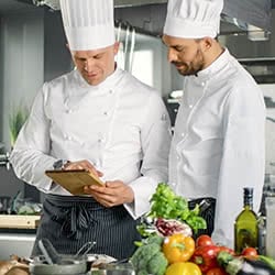 two chefs looking at a ticket