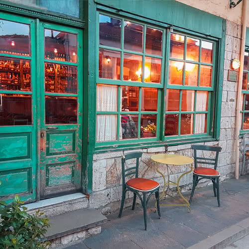 outside entrance of quaint bar with patio furniture