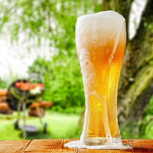 Pilsner glass overflowing with frothy beer