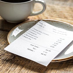 receipt laying on a saucer at a restaurant
