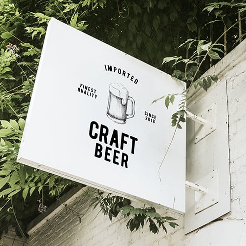 sign hanging on brick wall that says imported craft beer finest quality