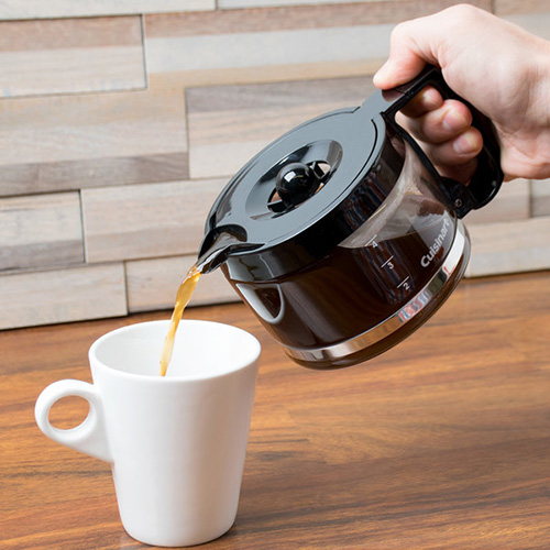 person pouring coffee into white mug from coffee pot