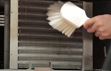 using a coil brush to clean refrigerator coils