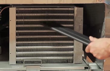 using a vacuum cleaner to clean refrigerator coils