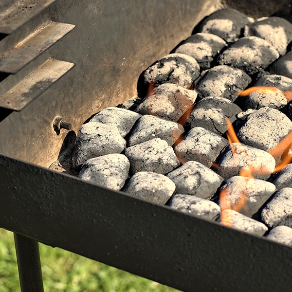 Charcoal briquettes burning on a grill