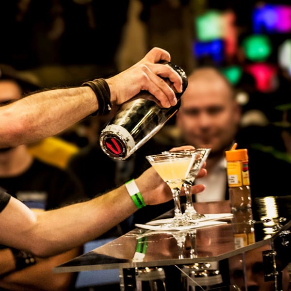 bartender straining drink into martini glass
