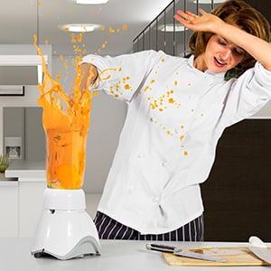 female chef shielding from spewing blender