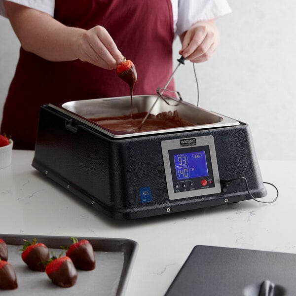Baker tempering chocolate for chocolate covered strawberries