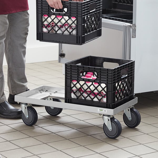 Employee loading a utility dolly with milk crates