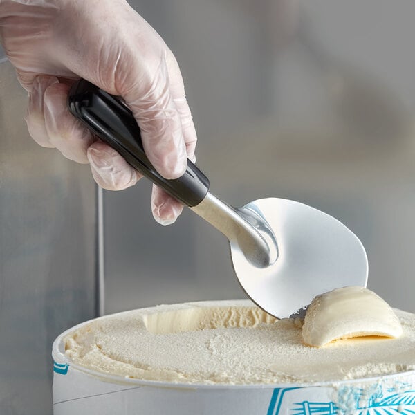 Ice cream spade scooping vanilla ice cream out of a tub