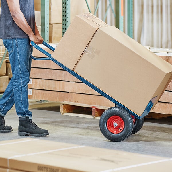 Person transporting a box with a hand truck
