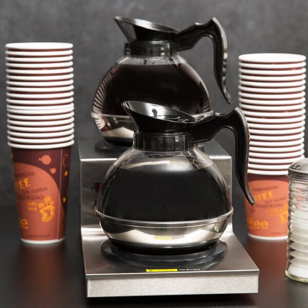 Two full coffee decanters on a coffee warmer