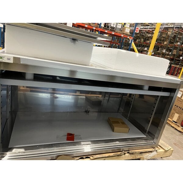 Scratch and Dent Regency 30" x 60" 16 Gauge Type 304 Stainless Steel Enclosed Base Sliding Door Table with Adjustable Midshelf and 6" Backsplash