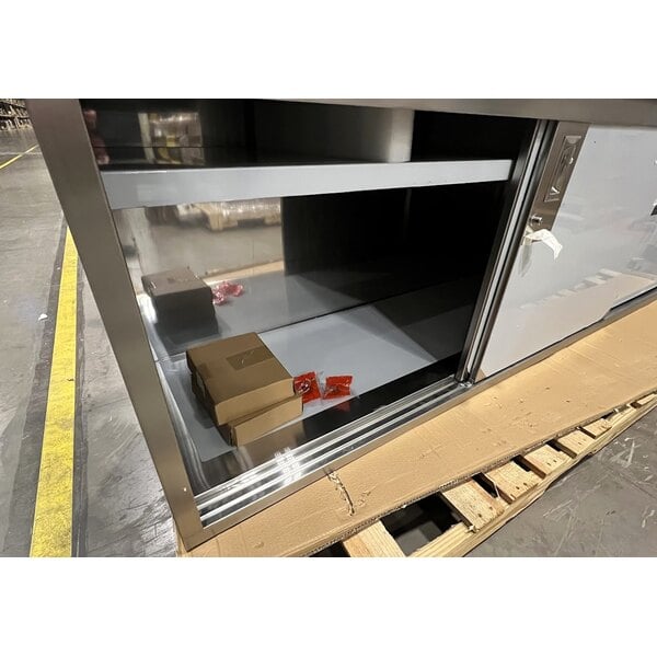 Scratch and Dent Regency 24" x 96" 16 Gauge Type 304 Stainless Steel Enclosed Base Sliding Door Table with Adjustable Midshelf and 6" Backsplash