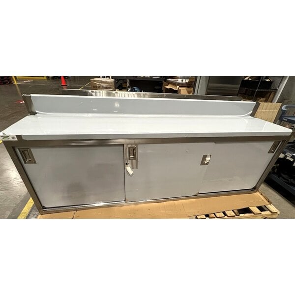 Scratch and Dent Regency 24" x 96" 16 Gauge Type 304 Stainless Steel Enclosed Base Sliding Door Table with Adjustable Midshelf and 6" Backsplash