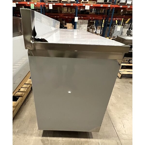 Scratch and Dent Regency 24" x 96" 16 Gauge Type 304 Stainless Steel Enclosed Base Sliding Door Table with Adjustable Midshelf and 6" Backsplash