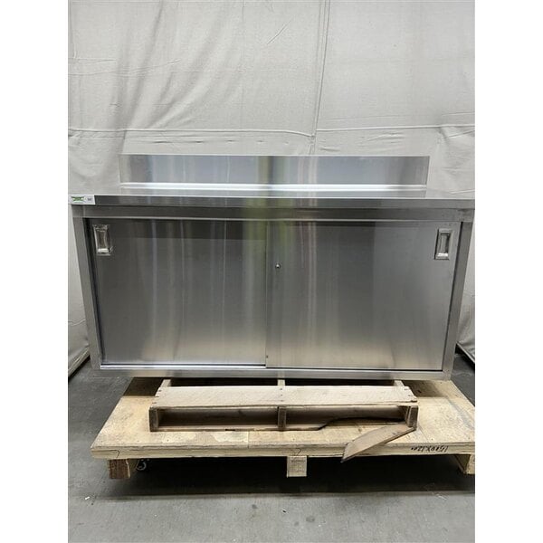 Scratch and Dent Regency 24" x 60" 16 Gauge Type 304 Stainless Steel Enclosed Base Sliding Door Table with Adjustable Midshelf and 6" Backsplash