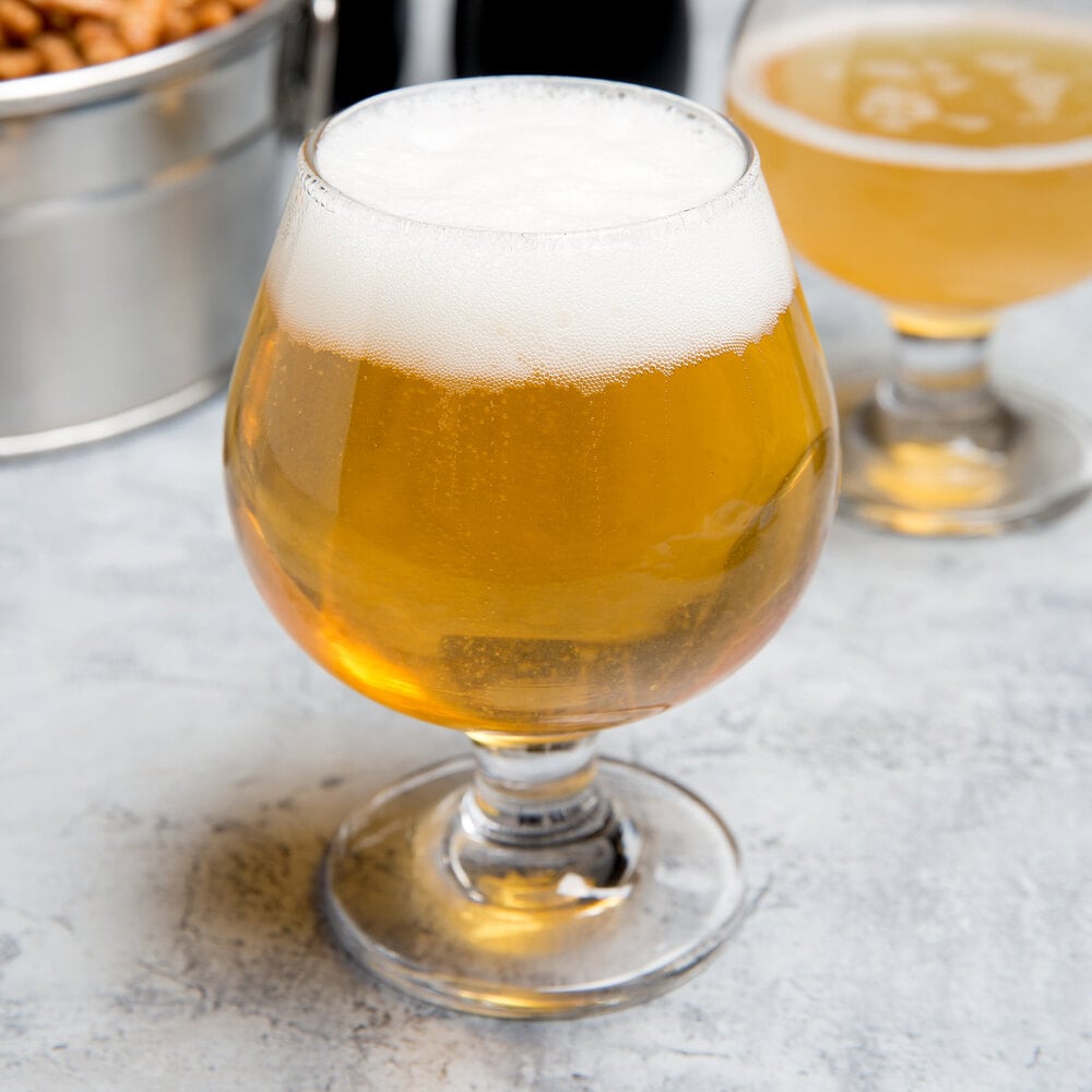 Bowl-shaped snifter glass filled with light-colored beer
