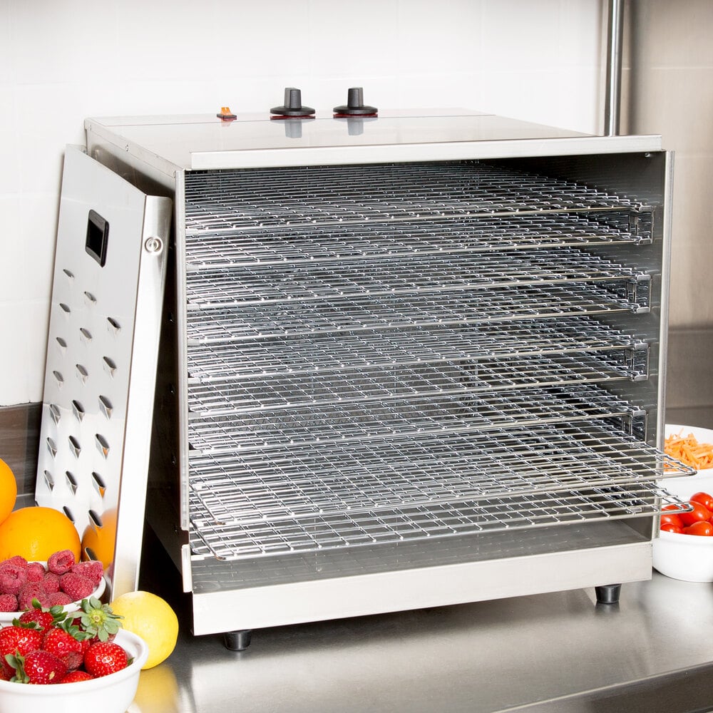 Open food dehydrator on a work table with fruit