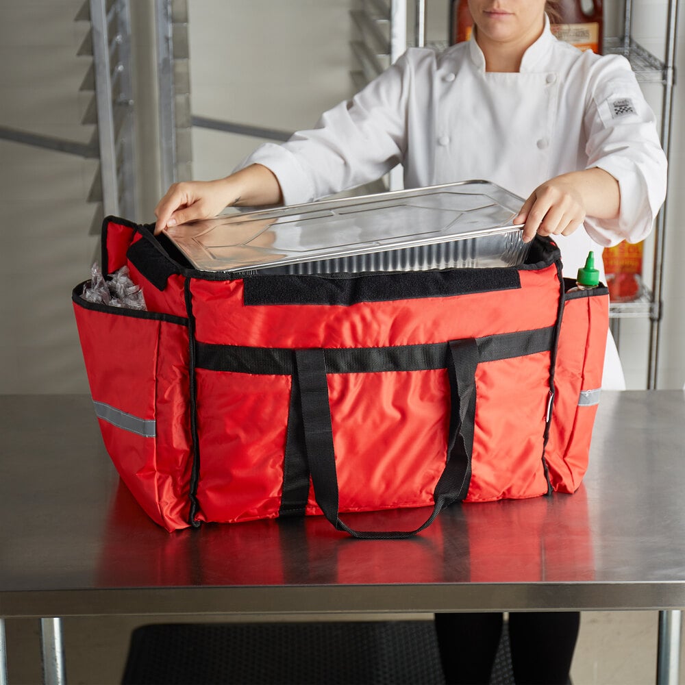ServIt red food delivery bag with a women removing an aluminum food pan