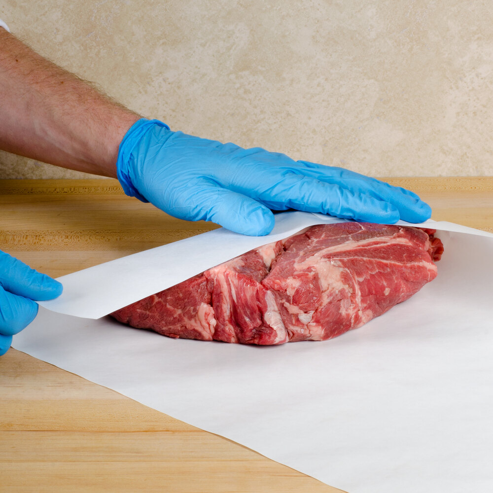 White freezer paper being wrapped around a cut of meat