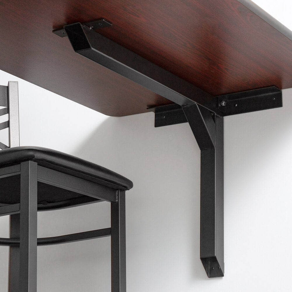 Black steel cantilever table bracket on white wall with wood tabletop attached