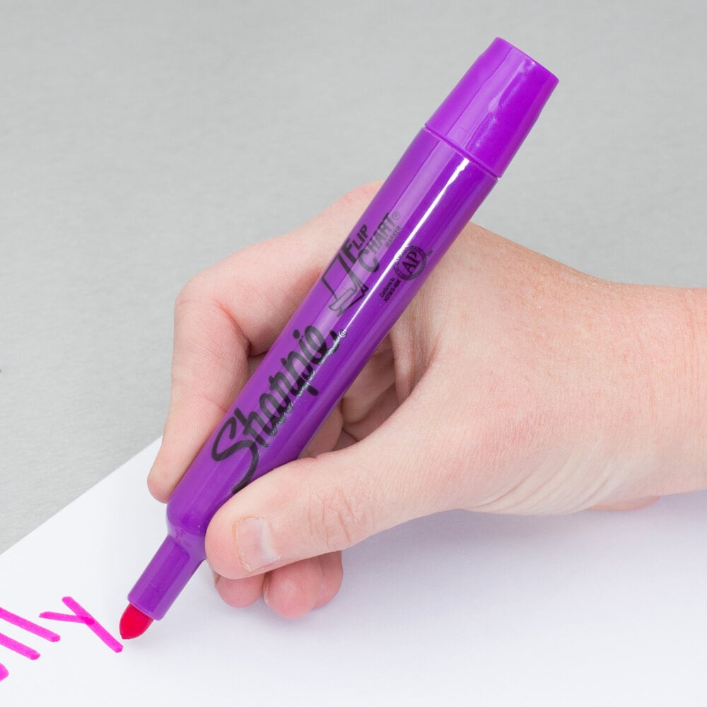 Person writing with a purple Sharpie bullet tip marker