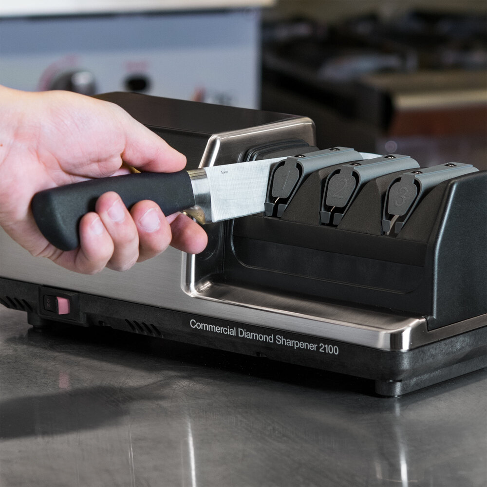 Hand pulling chef knife through Commercial Diamond Sharpener serrated knife sharpener