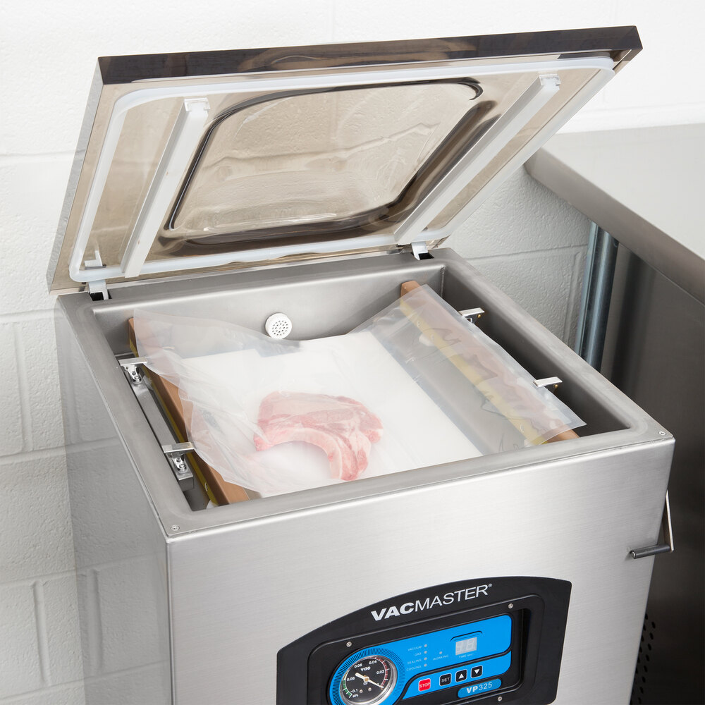 Gas flush vacuum sealer with lid lifted and sealed piece of meat inside