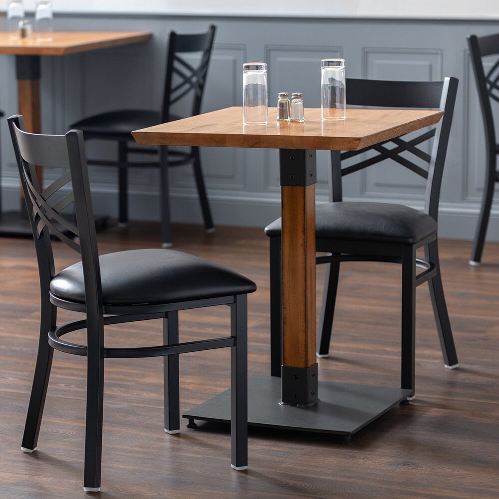 Black square table base with wood table top and two black chairs