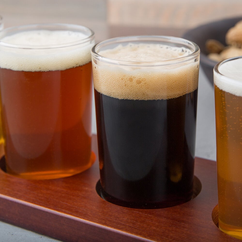 flight glasses of beer on a wooden flight paddle