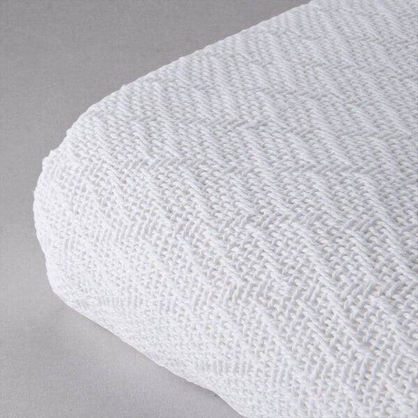A white Oxford thermal herringbone hotel blanket on a white surface.