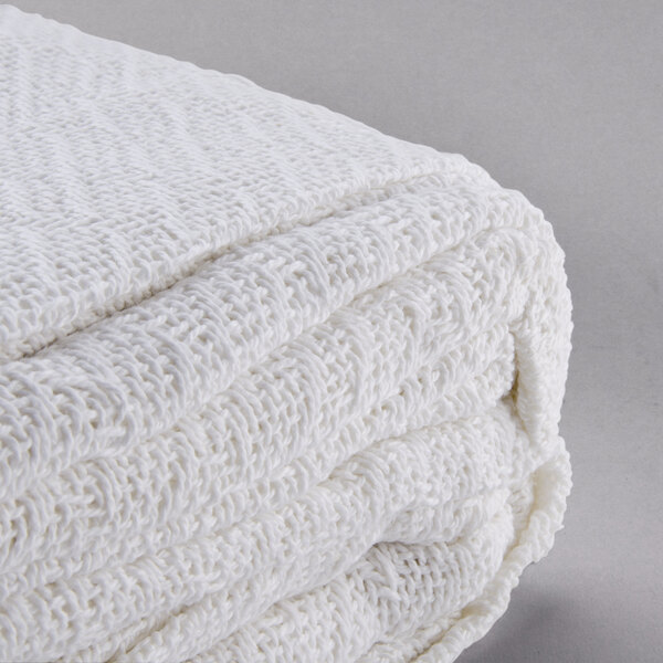 A folded white Oxford thermal herringbone hotel blanket.