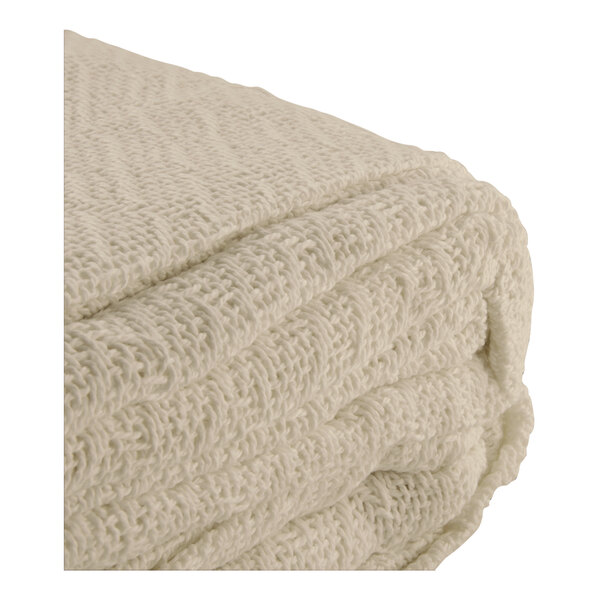 A folded beige herringbone hotel blanket.