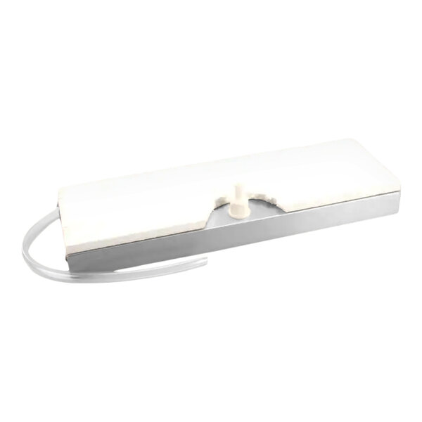 A rectangular white and silver component with a protruding nozzle and attached clear tubing, likely part of a drainage or fluid management system.