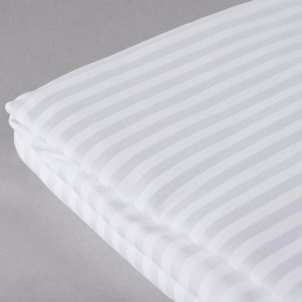A white and white striped Oxford Super Blend hotel duvet cover with a grey surface underneath.