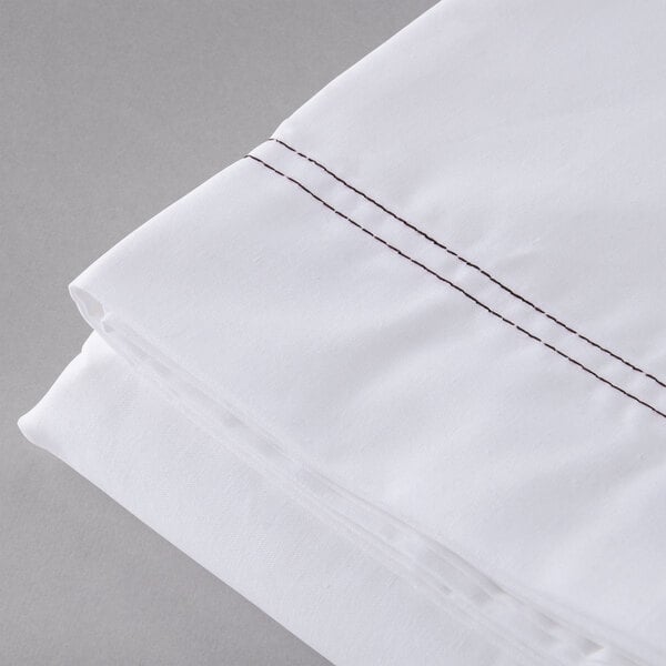 A white Oxford T200 Superblend flat sheet with brown stitching.