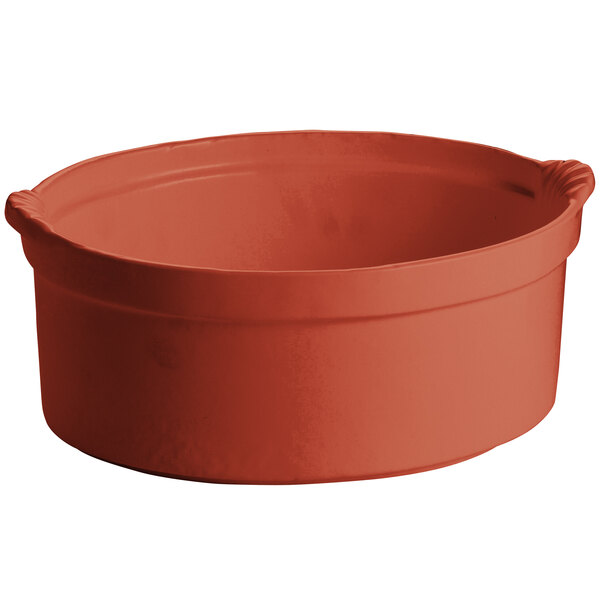 A copper casserole dish with handles and a shell design.